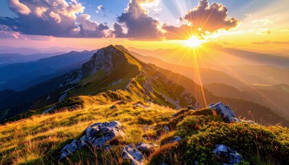 A breathtaking sunrise casts golden light and dramatic sunbeams over a sharp mountain ridge, highlighting the grassy slopes and rocky terrain.