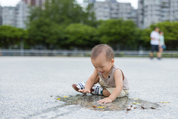 Baby playing with water on sunny day outdoor