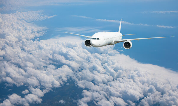 White passenger airplane flying in the sky amazing clouds in the background - Travel by air transport