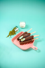 Mung bean ice cream coated with chocolate layer on a pink pan with mung bean in a glass and fresh milk.