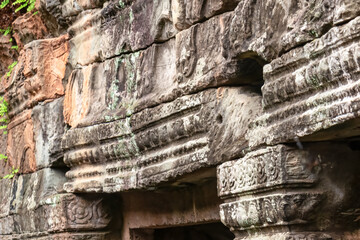 Eroded and weathered stone blocks form the textured wall of an ancient jungle temple, revealing beautiful decay and passage of time on historic Khmer architecture at Angkor Wat, Siem Reap, Cambodia.
