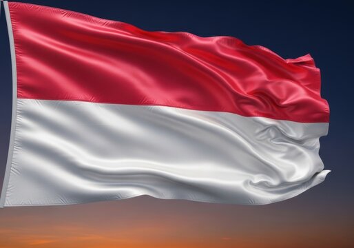 The national flag of indonesia, a simple yet striking design of red and white, billows gracefully against a dramatic sunset sky