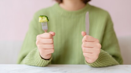 A woman holds a broccoli on the fork. Diet. Healthy nutrition