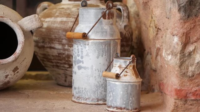 Vintage metal milk cans on rustic stone table