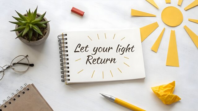 Flat lay of notebook displaying the inspirational words Return Light