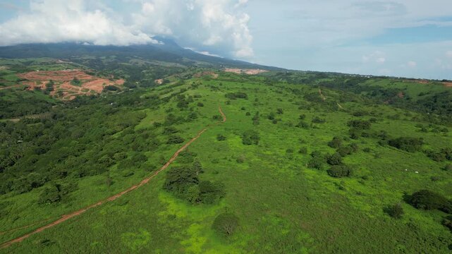 Level aerial showing lush greenery with a small trail winding through the hills, captured near the town port and coastal landscape of Mariveles, Bataan.
