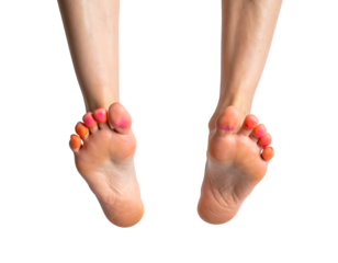 Close-up of two human feet hanging with painted nails against a stark black background