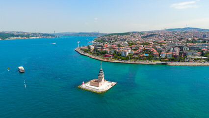 Fototapeta premium Istanbul, Turkey. Historic Maiden Tower Kiz Kulesi on rocky islet in Bosphorus with water taxis and small boats passing by on sunny day. Aerial View