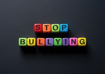 Obraz premium Colorful plastic blocks spelling stop bullying on a dark smooth background creating a bold simple scene that highlights a clear message about awareness support and safety