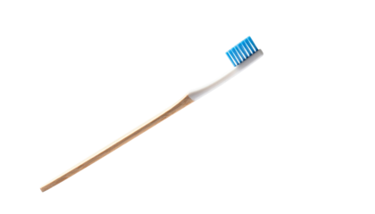 Beige-handled toothbrush with blue bristles on black backdrop