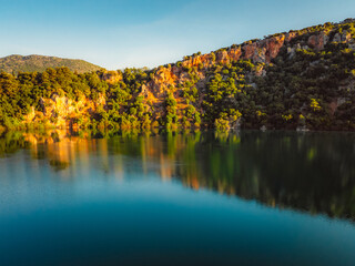 Canoeing and sup standup paddleboarding at mountains Ziros lake in Preveza Greece at sunrise.