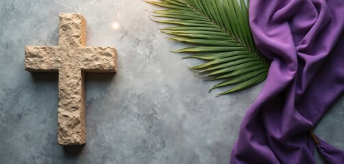 Stone cross, fresh green palm leaf, flowing purple cloth rest on textured grey background. Spiritual arrangement faith, devotion, solemn remembrance for Christian observances like Lent, Easter.