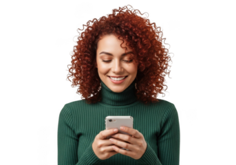 Smiling young woman with vibrant curly red hair wearing a green turtleneck holding a smartphone isolated on transparent background