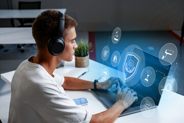 Young man using laptop with digital security interface in modern office setting