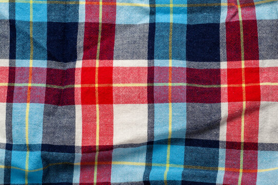Colorful plaid fabric background with red, blue, and yellow squares