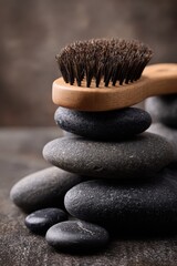 Serene Stack of Spa Stones with Wooden Brush, Textured Background, Wellness Concept.