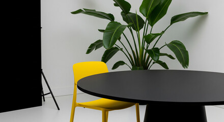 workspace interior, yellow chair, black table, tropical plant, modern office, bold colors, minimal style, interior decor, green leaves, plant background, clean design, contemporary workspace, studio l