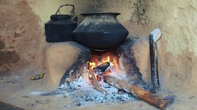 A traditional Uttarakhand village cooking setup with a large pot heating over a wood-fired chulha, showing rustic mountain life and the simplicity of rural Indian kitchens.