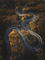 Aerial view of cars driving on the forest road between Domanic and Inegol in autumn, taken with a drone