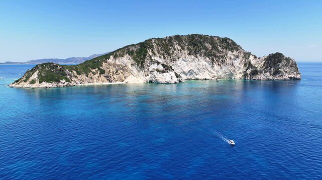 Aerial drone cinematic video of scenic caves and turquoise beach in paradise island of Marathonisi in bay of Laganas, visited by small boats a true tourist attraction, Zakithnos island, Ionian, Greece