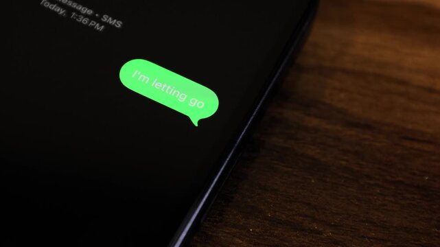 Close-up view of a smartphone screen showing an outgoing “I'm Letting Go” text message in a green bubble, captured as it sends with a smooth popup animation.