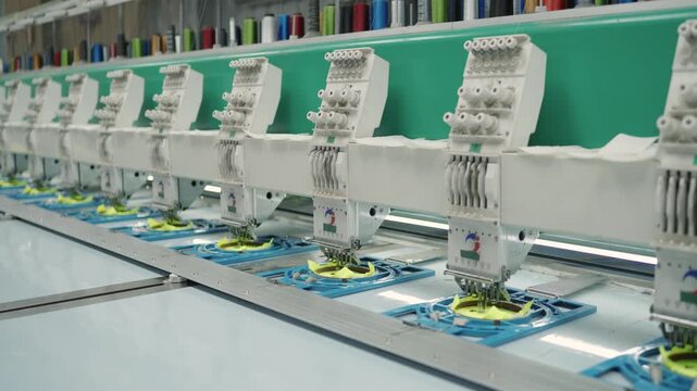 Close-up of Industrial Multi-Head Embroidery Machine Sewing Yellow Fabric