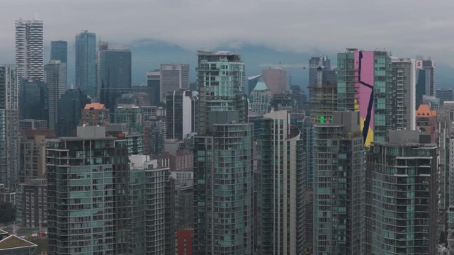 Aerial telephoto dolly shot of skyscrapers in downtown Vancouver on a rainy day in British Columbia, Canada. 4K