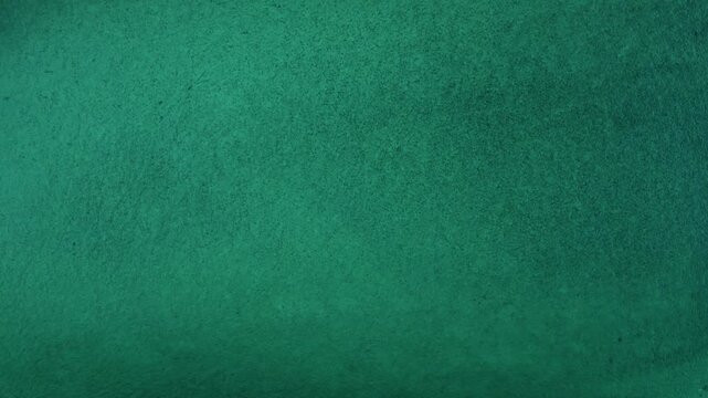 A broad sweep of green-turquoise water reveals gentle shifts in tone and soft underwater textures that create a calm, abstract marine surface shaped by natural light and depth.