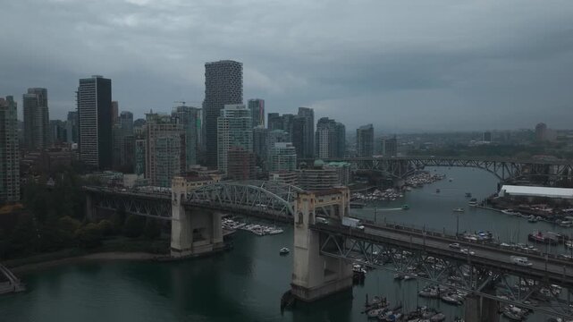 Aerial descending and panning shot Burrard Bridge spanning False Creek on a rainy day in Vancouver, British Columbia, Canada. 4K
