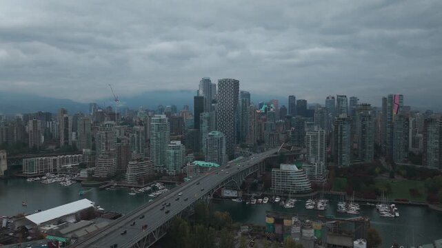 Descending and panning aerial shot of Granville Bridge in downtown Vancouver on a rainy morning in British Columbia, Canada. 4K
