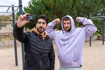 Men friends vlogging workout in park selfie, training for fitness goals, exercising outdoors, healthy lifestyle
