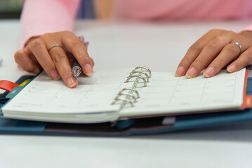 Close up view  woman sit at table hold take  notes to paper notebook working .businesswoman