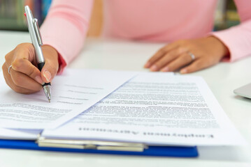 Close up view  woman sit at table hold take  notes to paper notebook working .businesswoman
