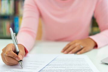 Close up view  woman sit at table hold take  notes to paper notebook working .businesswoman