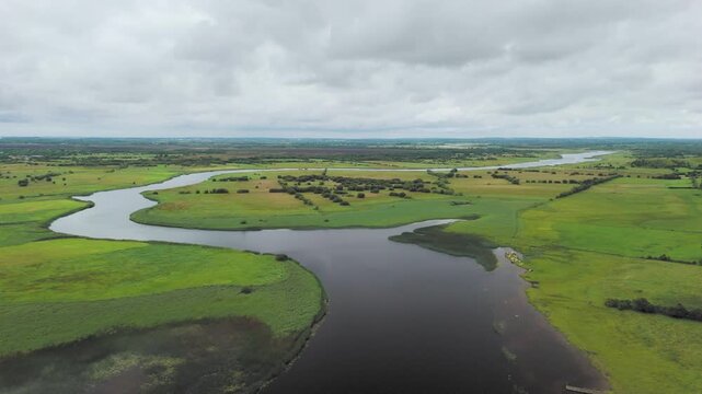 Aerial drone view of Shannon river and countryside rural irish landscape, Clonmacnoise monastery ruins and small marina with vacation river boats, county Offaly, Ireland. 4K drone footage
