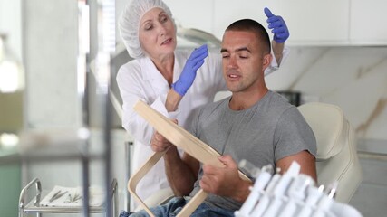 Female cosmetologist confidently presents cosmetic procedure's results to male client using mirror. 
