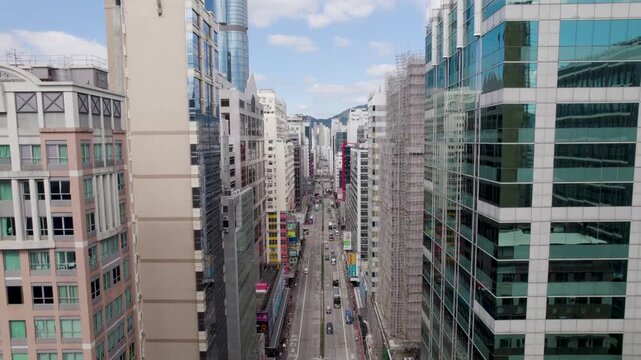Hong Kong City fly-through Kowloon District between buildings down the Nathan road, aerial view of a densely populated Mong Kok area