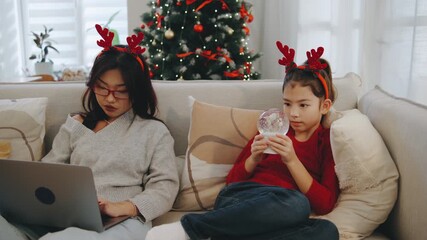 Family enjoys cozy Christmas time together with a decorated tree, holiday decorations, and festive attire while preparing for New Year celebrations