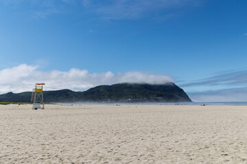 Empty Oregon beach with forested hillside in background