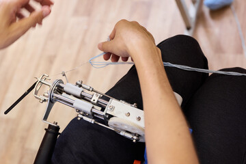 Hands using a sewing machine to stitch fabric together