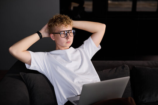 Young man relaxing while using laptop at home in the evening