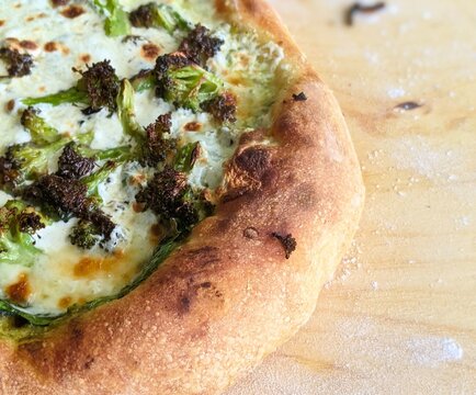 Up Close Broccoli Pizza with Air Bubbles in Crust and Extra Cheese