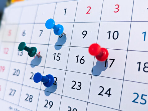 close-up calendar showing multiple pushpins marking various dates, the keywords will focus on deadlines, events, planning, and organization.