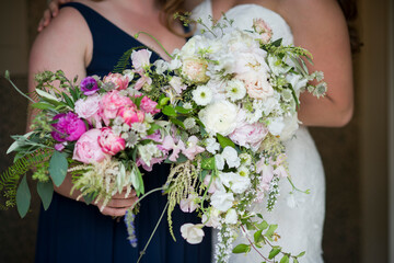 Bride and Bridesmaid Holding Vibrant and Soft Floral Bouquets