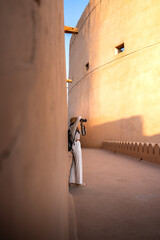Woman photographer exploring historic bahla fort in oman