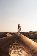Woman exploring desert sand dunes enjoying oman travel lifestyle