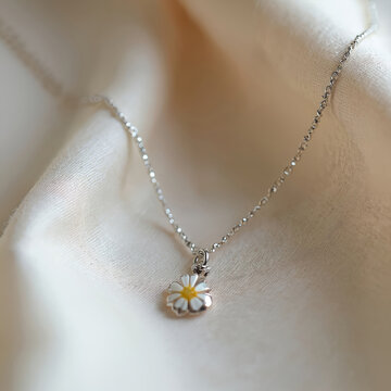 Delicate silver necklace with a small daisy pendant. Handcrafted jewelry with tiny flower charm. Unique artisan accessory. Elegant, feminine, and dainty.