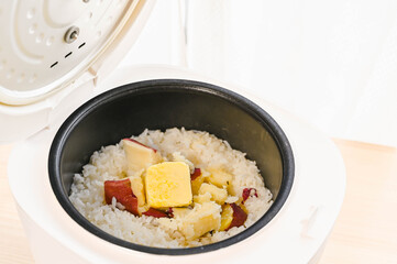 炊きあがったサツマイモご飯にバターを加える