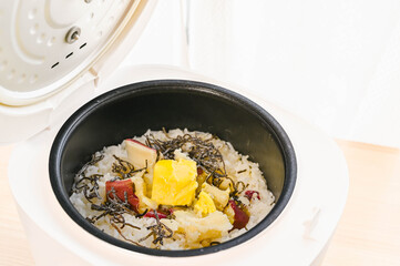 炊きあがったサツマイモご飯にバターと塩昆布を加える