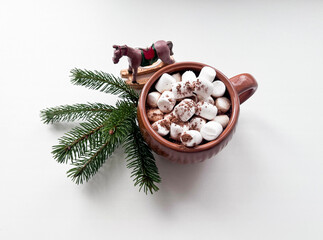 A cup of cocoa and marshmallows, a fir branch and a Christmas tree toy 